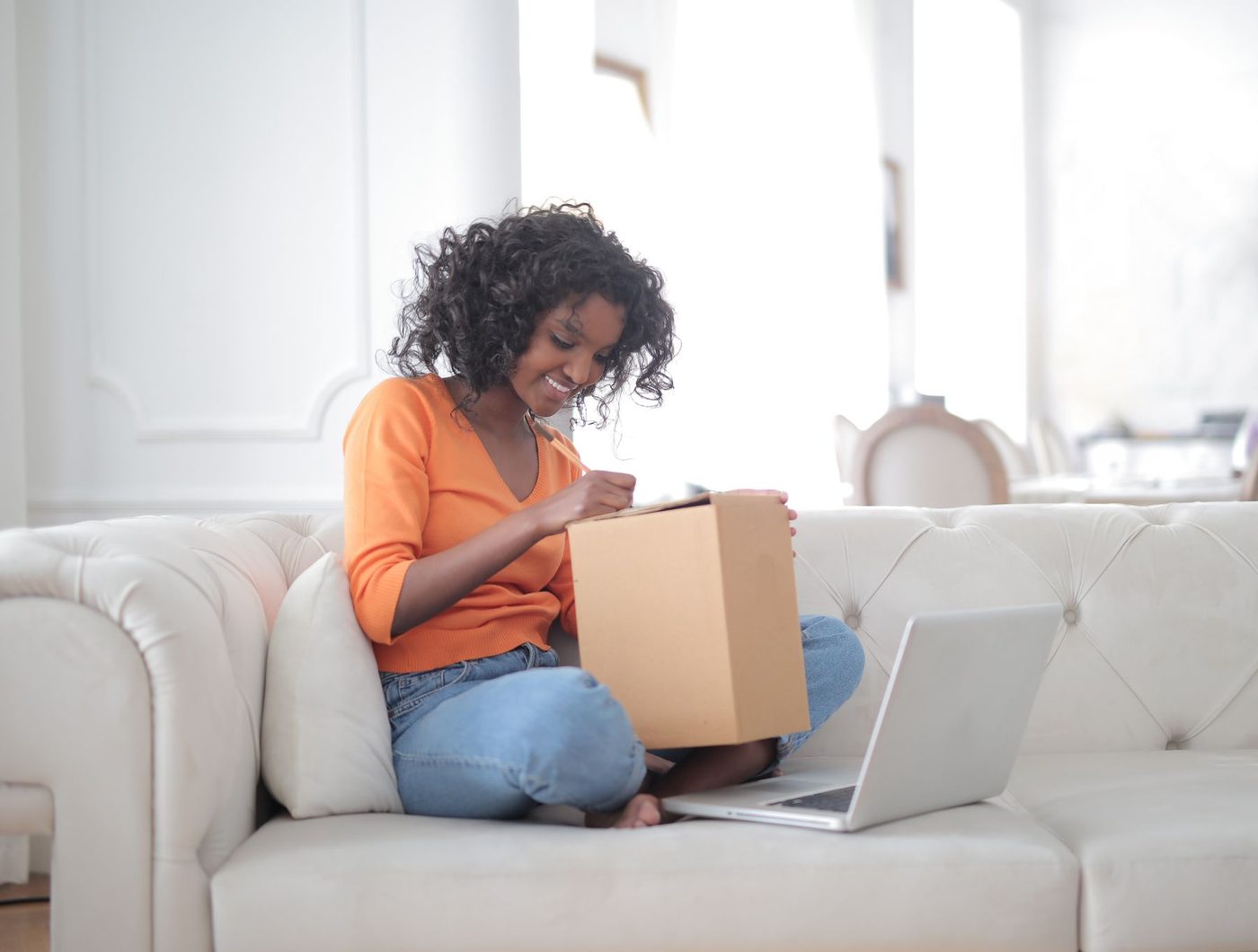A customer opening her delivery at home next to her laptop